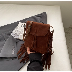 Détail du sac bandoulière bohème en daim marron foncé avec de longues franges et glands