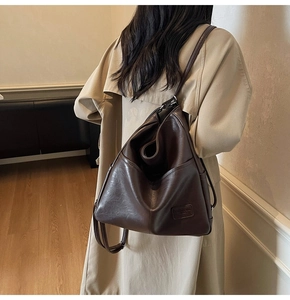 Deep brown retro soft leather tote bag shown in use with stylish trench coat outfit