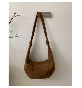 Detail of vintage brown suede hobo bag with unique knotted strap and paneled design
