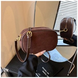 Detail of coffee suede crossbody bag with adjustable leather strap and golden hardware