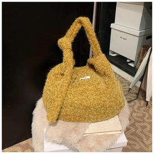 Detail view of yellow fuzzy wool tote bag featuring a decorative wide knot on the shoulder strap