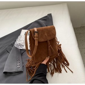 Gros plan du sac bandoulière bohème en daim marron avec de longues franges sur le côté