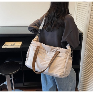 Close-up of durable fabric cross-body tote bag with wide straps and large zipper pocket