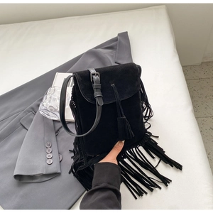 Détail de sac bandoulière en daim noir avec de longues franges et une fine bandoulière