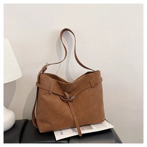 Detail of a large brown suede tote bag featuring a minimalist knotted strap decoration