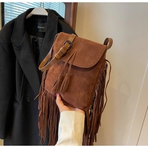 Vue détaillée du sac bandoulière en daim marron avec longues franges et boucles en métal noir