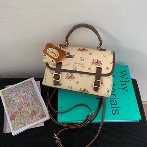 Détail du sac bandoulière en cuir PU beige avec motifs animaux et pendentif ours
