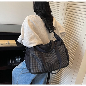 Detail of checkered patchwork tote bag featuring side pockets and adjustable strap