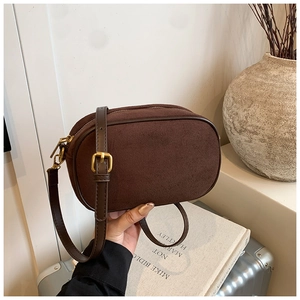 Detail of vintage dark brown matte crossbody bag with golden metal hardware and zipper