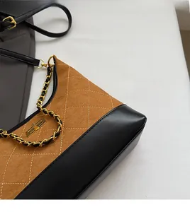Detail of retro quilted patchwork bag showing gold twist lock and chain strap texture