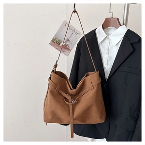 Macro detail of brown suede hobo tote bag with buckled strap and soft drape