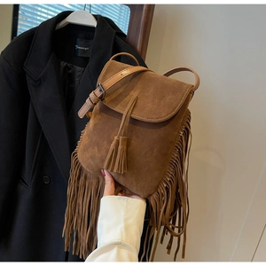 Détail d'un sac bandoulière en daim marron avec de longues franges bohèmes en cuir
