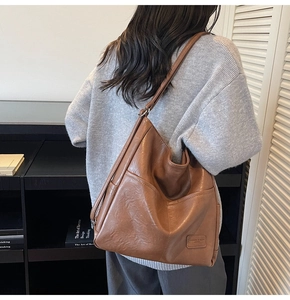 Detail view of brown vintage leather tote bag with functional double front pockets and texture