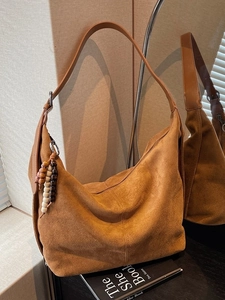 Brown suede hobo bag with colorful wooden beads and a spacious minimalist design
