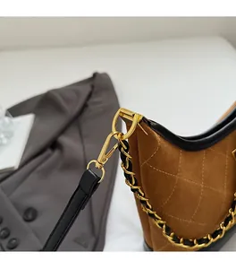 Detail of high-quality gold hardware and chain on caramel quilted crossbody bag