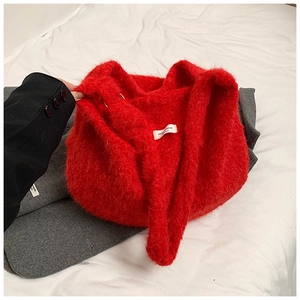 Détail d'un cabas en fausse fourrure rouge avec étiquette blanche et texture douce