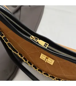 Close-up of golden zipper and quilted suede texture on trendy crossbody bag