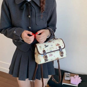 Détail d'un sac à dos en similicuir beige avec imprimés de chiens et bordures marron