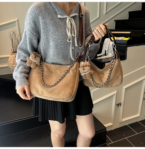 Detail of brown faux suede crossbody bag with gold chain and plush bear charm