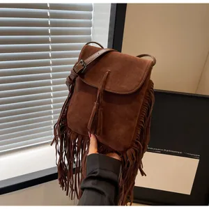 Détail du sac bandoulière bohème en daim marron avec de longues franges et glands