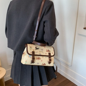 Détail d'un sac cabas vintage blanc avec imprimés de chiots colorés et boucles décoratives