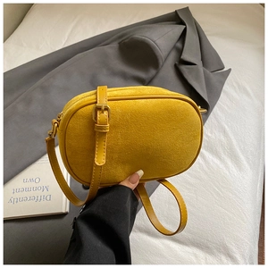 Detail view of mustard yellow frosted leather crossbody bag with adjustable metal buckle