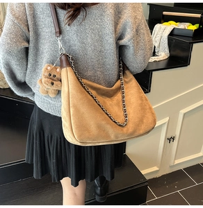 Brown suede crescent bag with metal chain strap and cute bear plush pendant detail