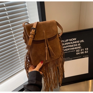 Détail du sac à bandoulière en daim marron avec de longues franges et fermeture à rabat