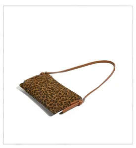 Detail shot of leopard print crossbody bag featuring brown texture and metal buckle