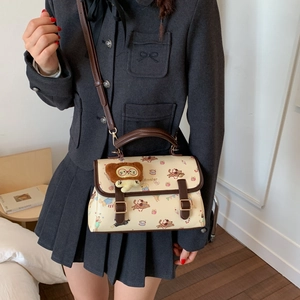 Détail du sac bandoulière rétro crème avec imprimé chien et breloque ourson