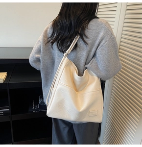 Cream white PU leather hobo bag featuring a functional side pocket and grainy texture