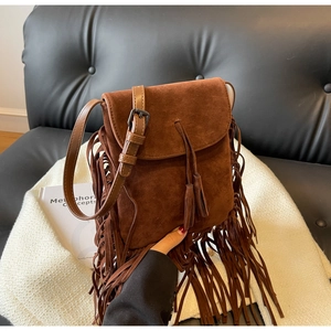 Gros plan du sac bandoulière en daim marron avec longues franges et détails bohèmes