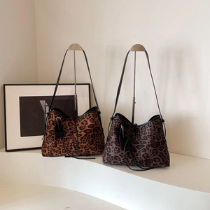 Detail view of leopard print tote bags with drawstring closure and slim shoulder straps