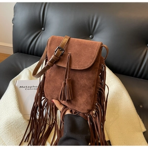 Détail du sac bohème en daim marron avec de longues franges et une boucle en métal