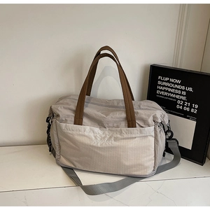 Macro detail of spacious grey tote bag with front plaid pocket and adjustable strap