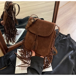 Détail du sac bandoulière bohème en daim marron foncé avec de longues franges
