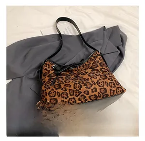 Detail shot of leopard print tote bag with black leather straps and drawstring closure