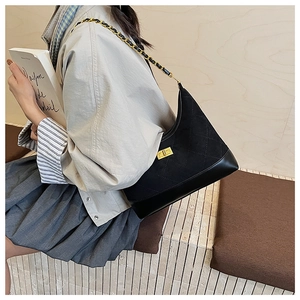 Detail view of quilted diamond pattern and gold-tone chain strap on black hobo bag