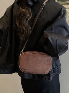 Retro dark brown matte suede crossbody bag with gold hardware shown on a model