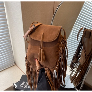Détail du sac bandoulière en daim marron avec de longues franges style bohème