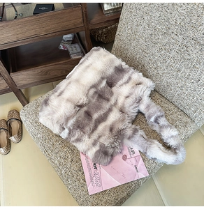 Détail d'un sac cabas en fausse fourrure à texture marbrée grise sur une chaise
