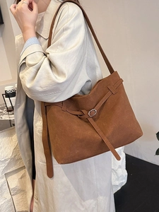 Brown frosted suede tote bag with decorative buckle strap in a minimalist style