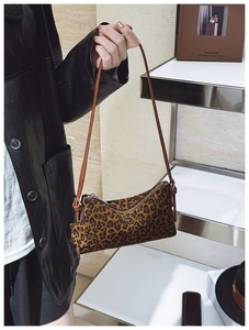 Detail of leopard print underarm bag featuring silver zipper and slim leather shoulder strap