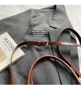 Détail de la bandoulière réglable en cuir marron avec boucle argentée pour ce sac