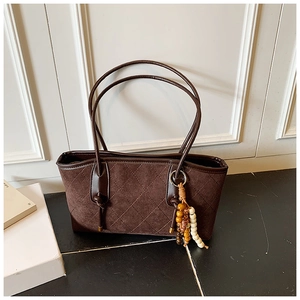 Close-up of vintage dark brown quilted suede tote bag with bohemian bead charm detail