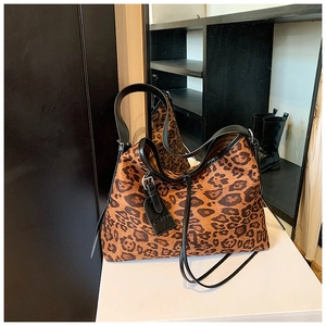 Detail of leopard print tote bag with soft frosted texture and black leather fashion tag