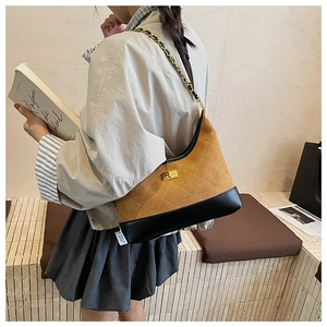 Detail of rhombic quilted crossbody bag in brown suede with golden twist lock