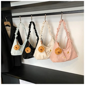 Detail of four hobo bags in blue, black, white, and pink with plush bear charms