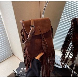 Détail du sac bandoulière en daim marron foncé avec de longues franges et un gland