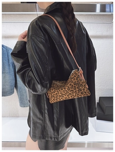 Close-up of leopard print shoulder bag with star charm and brown leather strap details